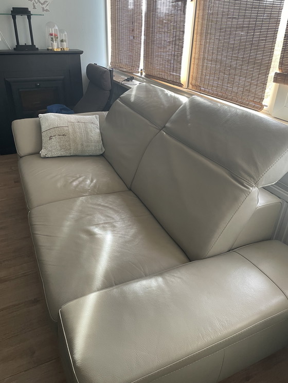 Image 1 of Grijze leren bank met verstelbare hoofd-arm leuningen.