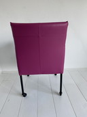 Luxurious fuchsia leather dining chairs with wheels