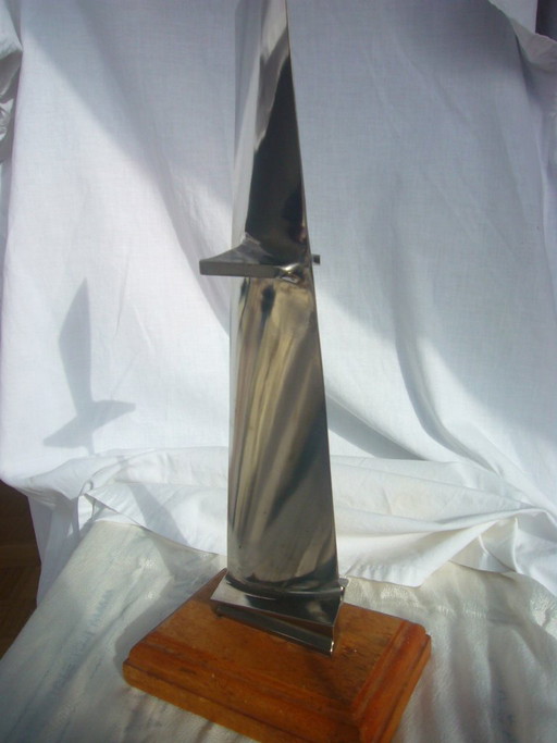 Objeto de titanio metálico, obra de arte, escultura hecha a partir de una pala de ventilador, pala de motor, ¿posiblemente