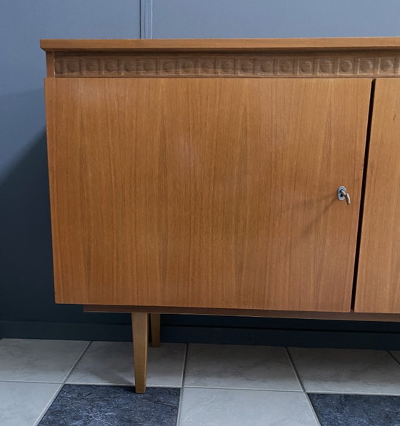 Image 1 of Dressoir uit de jaren 70 met decoratieve lijn boven de deuren.