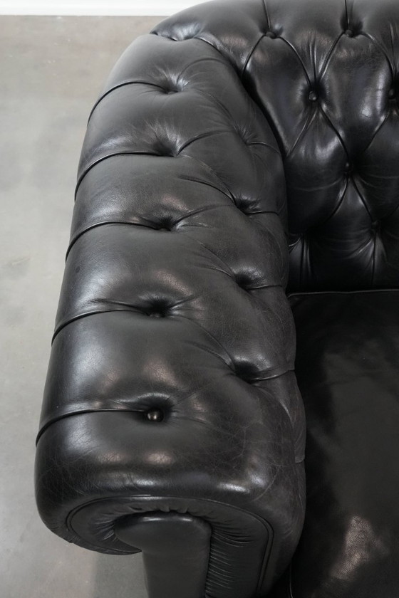 Image 1 of Set consisting of a black Chesterfield sofa, armchair and footstool made of cowhide