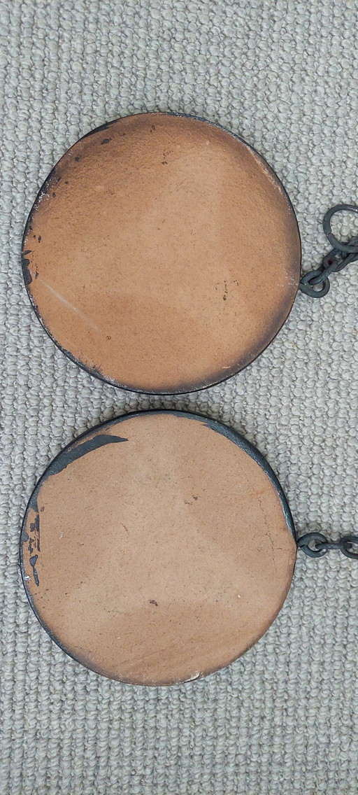 Piastrelle decorative in terracotta con motivi floreali smaltati.