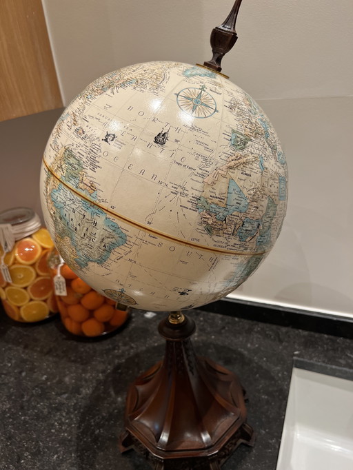 Wereldbol op mooi uitgekerfde houten voet