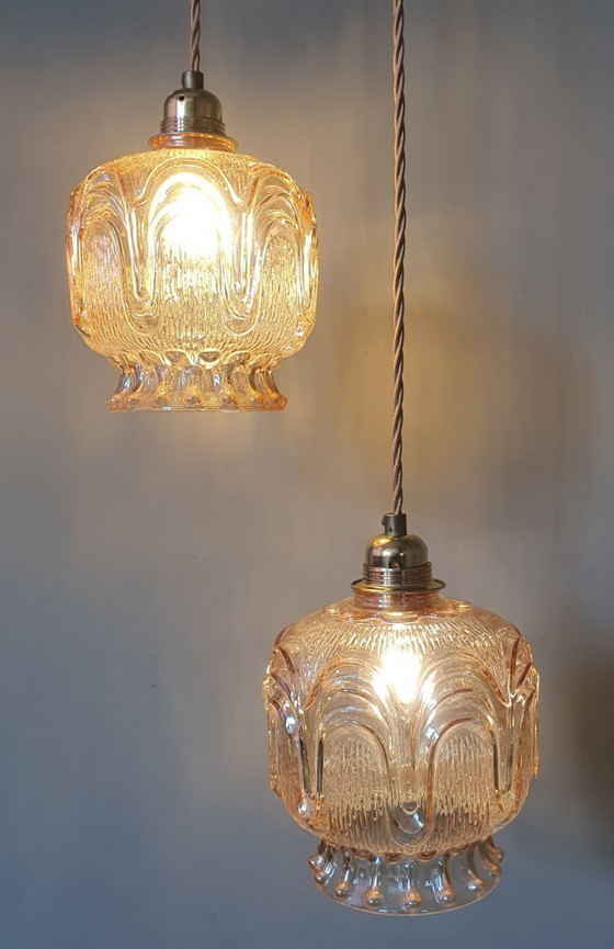 Image 1 of Set of 2 Vintage textured rose / amber tinted pendant lamps - mid-century design.
