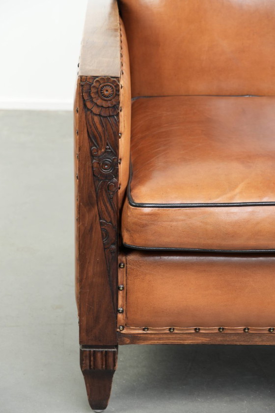 Image 1 of Schapenleren art Deco fauteuil met mooi houtsnijwerk en zwarte biezen