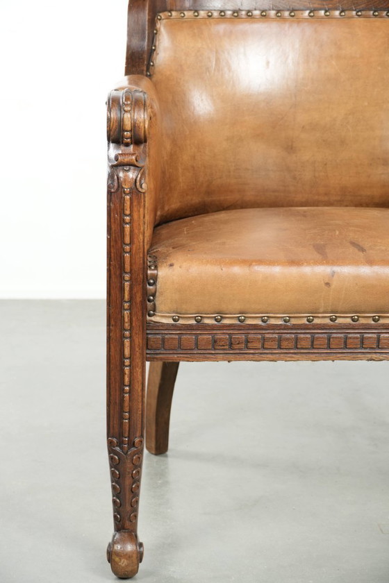 Image 1 of Antique armchair of sheepskin and wood with decorative nails and beautiful woodwork