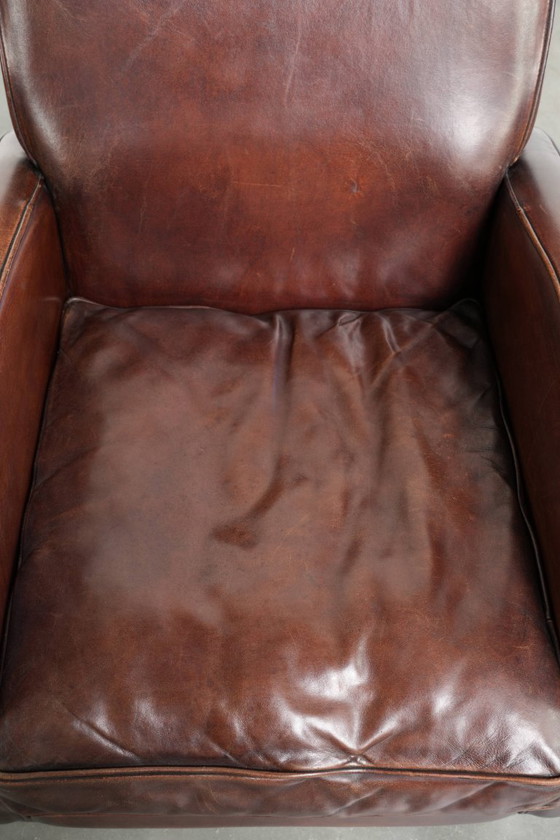 Image 1 of 2x dunkel cognacfarbene Schaffellsessel mit abgerundeten Formen und elegantem Design