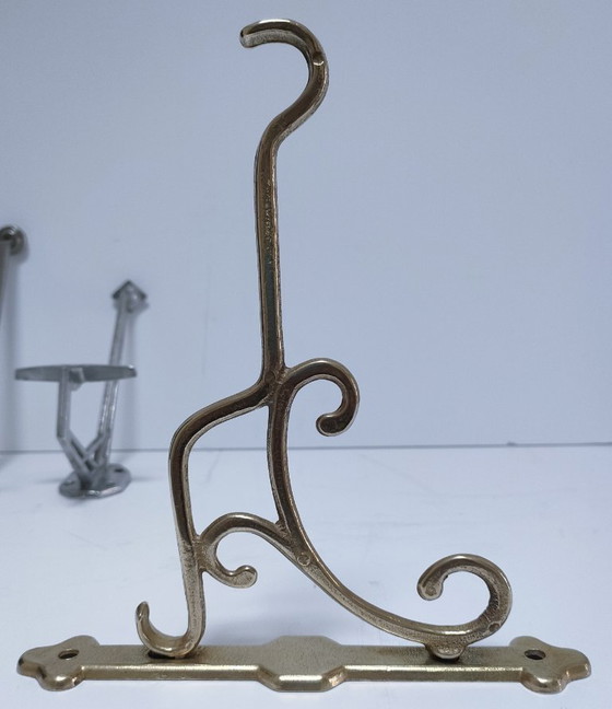 Image 1 of Tres ganchos para abrigos de latón, cromo y aluminio.
