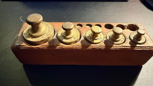 Juego de pesas antiguas de latón en soporte original