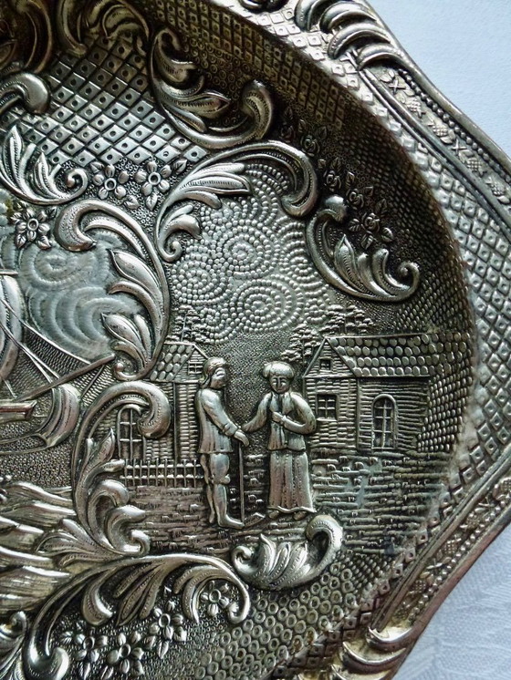 Image 1 of Decoratief verzilverde schaal met een gedetailleerde reliëfvoorstelling.