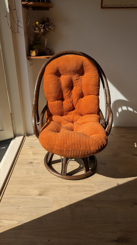Image 1 of Draaibare rotanstoel uit de jaren 70 met oranje corduroy kussen