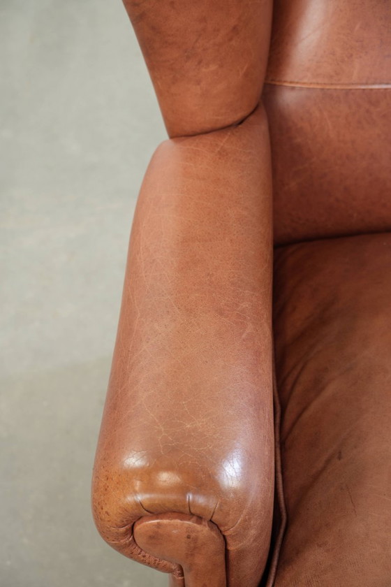 Image 1 of Poltrona a orecchioni color cognac chiaro, rivestita in pelle bovina, dal caratteristico look inglese.