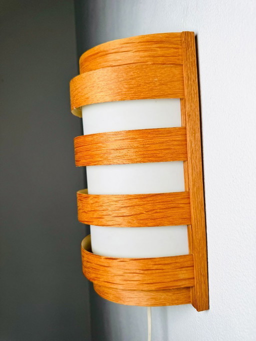 Elegant mid-century wall lamp crafted from curved pine veneer, produced in Sweden during the 1960s.