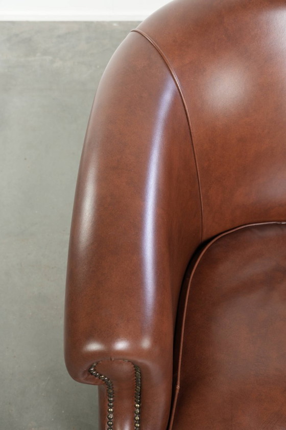 Image 1 of Bellissima e comoda poltrona club in stile inglese, rivestita in pelle di vacchetta color cognac.