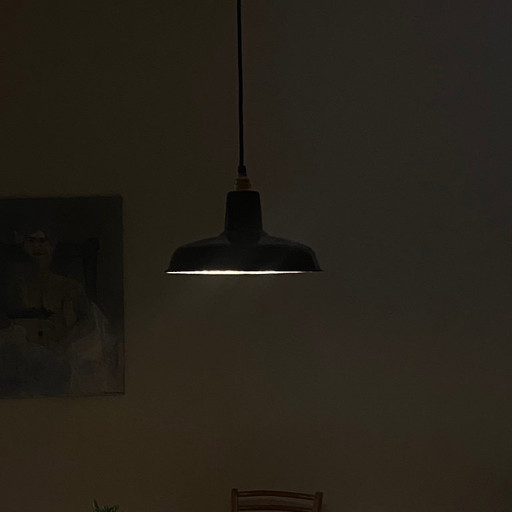 Antieke hanglamp met zwarte geëmailleerde metalen lampenkap.