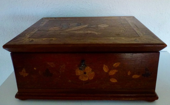 Image 1 of Una scatola di legno d'epoca con intarsi floreali