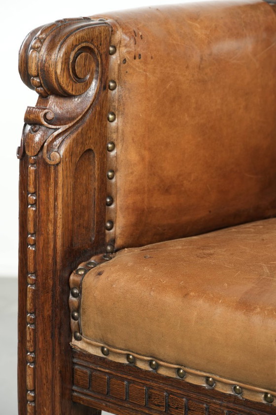 Image 1 of Antique armchair of sheepskin and wood with decorative nails and beautiful woodwork
