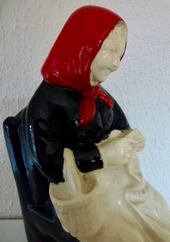 Image 1 of A set of decorative bookends depicting an elderly couple sitting on chairs.