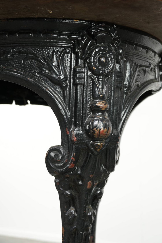 Image 1 of Antieke Engelse pub/ bistro/ bijzettafel uit de 19e eeuw met een gietijzeren onderstel en een rond houten tafelblad