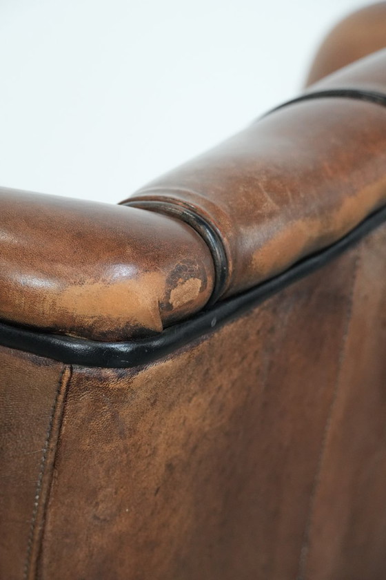 Image 1 of Poltrona a orecchioni in pelle di pecora con profili neri, in buone condizioni.