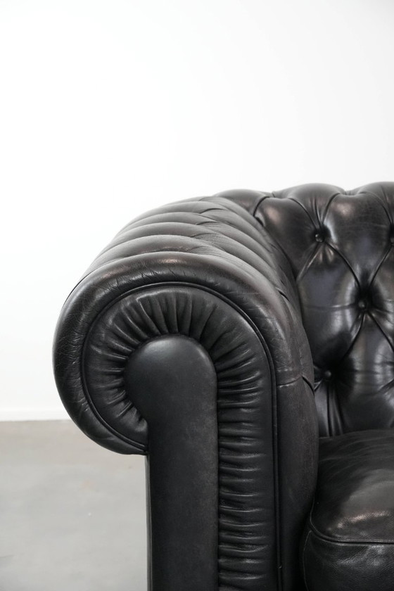 Image 1 of Set consisting of a black Chesterfield sofa, armchair and footstool made of cowhide