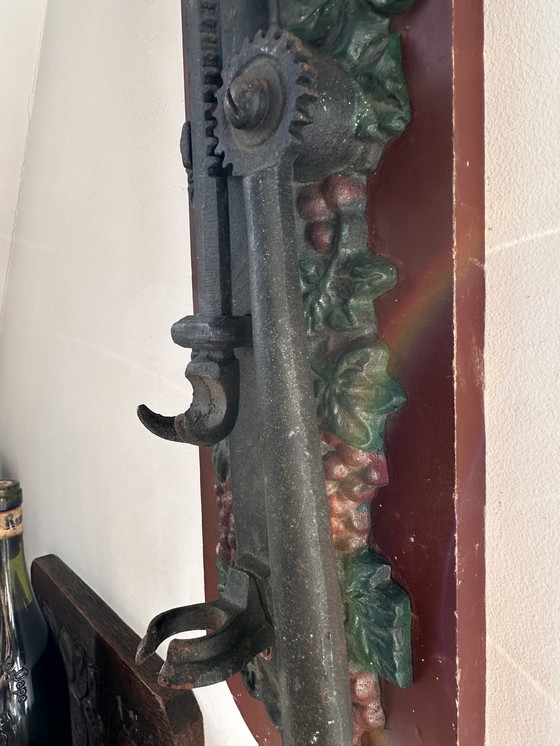 Image 1 of Ouvre-bouteille mural ancien en fonte à motif de raisin – style auberge (vers 1900)