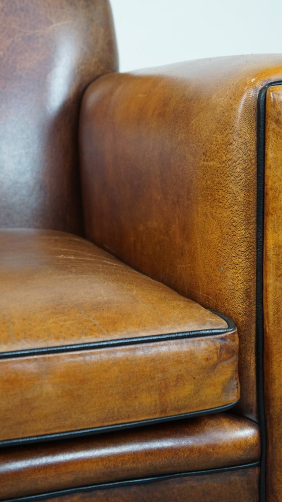 Image 1 of Sillón de diseño Art Déco en buen estado, con un acabado elegante y ribetes negros.
