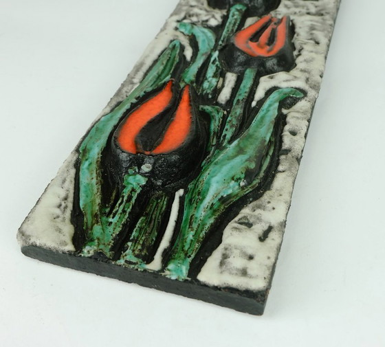 Image 1 of Keramische wandtegel uit de jaren 70 met tulpmotief en een ruwe glazuurlaag.