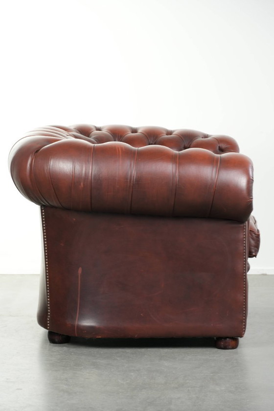 Image 1 of Beautiful red/brown cowhide Chesterfield armchair in a classic English style