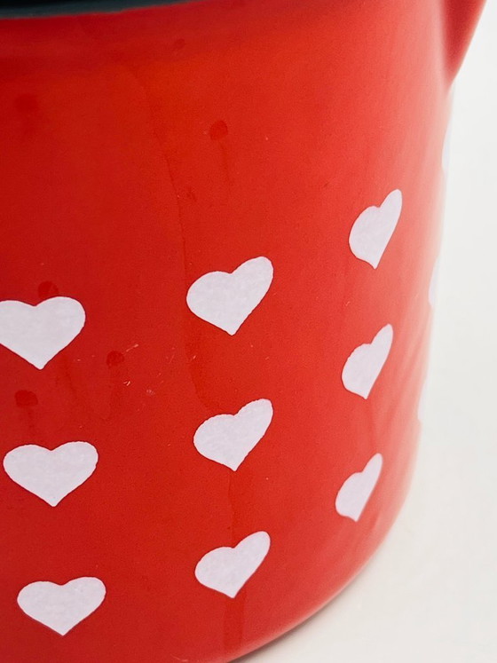 Image 1 of Jarra antigua esmaltada en rojo con corazones de tamaño gradual.