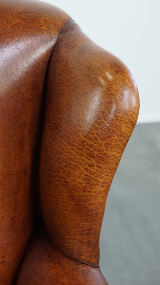 Image 1 of Comfortabele schapenleren oorfauteuil met een prachtige warme kleurstelling en een afwerking met stiksels en zwarte biezen