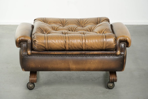Unique and elegant English Chesterfield ottoman in cowhide leather on wheels and finished with decorative nails.
