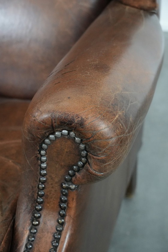 Image 1 of Caratteristica poltrona vintage di grandi dimensioni con ali laterali, realizzata in pelle di pecora.