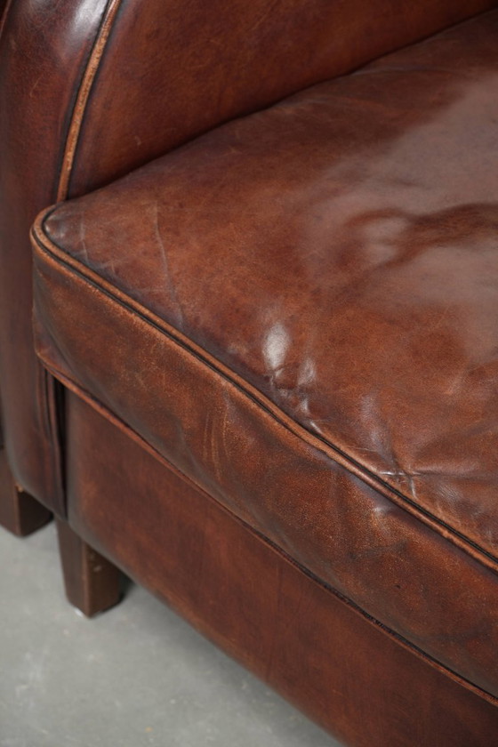 Image 1 of 2x dunkel cognacfarbene Schaffellsessel mit abgerundeten Formen und elegantem Design
