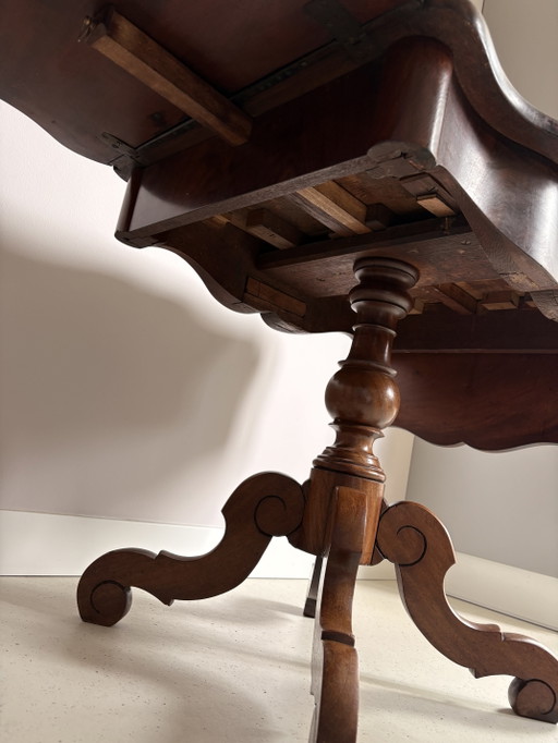 Tavolo vintage inglese in noce con gambe a ribalta, piano a crosta di torta e gamba centrale a cabriole.