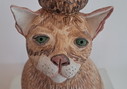 Escultura de cerámica de un gato con compañeros de juego.