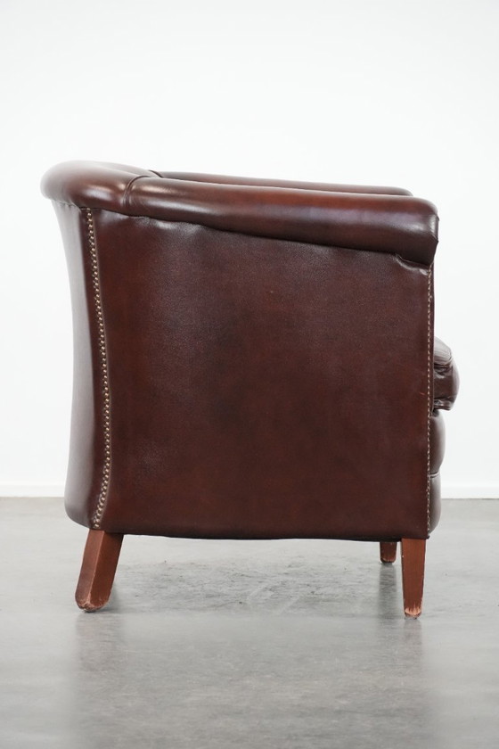 Image 1 of Sillón club de piel de vaca en buen estado, de un lujoso color rojo/marrón.