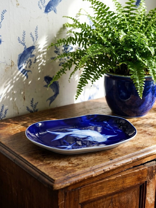 Plato pequeño de porcelana de Limoges con esmalte azul y decoración de peces al estilo japonés.