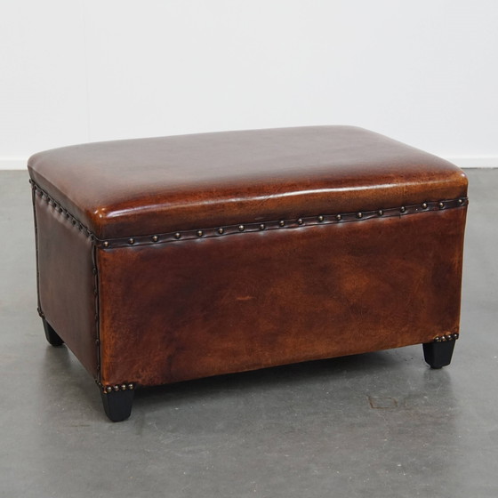 Image 1 of Cognac-kleurige schapenleren hocker met siernagels