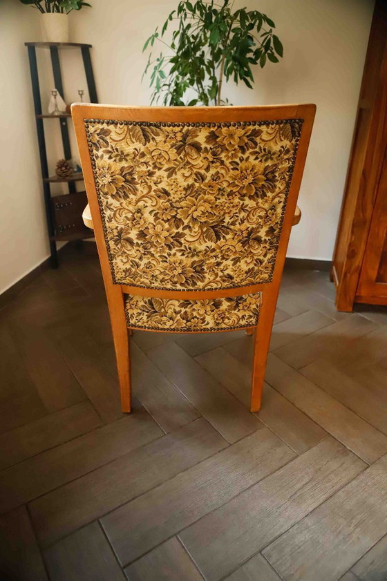 Image 1 of Vintage salonfauteuil met bloemenpatroon op de bekleding en sierlijke armleuningen.