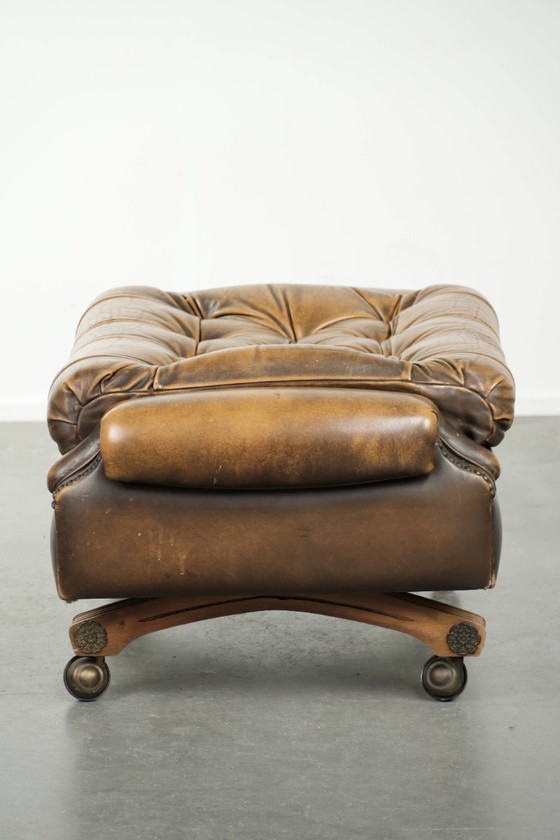 Image 1 of Exclusivo y elegante puf inglés Chesterfield de piel de vacuno con ruedas y acabado con clavos decorativos.