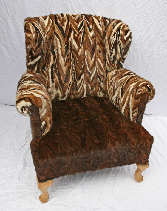 Image 1 of Antieke oorfauteuil met hergebruikte bontjassen bekleed (1910) 