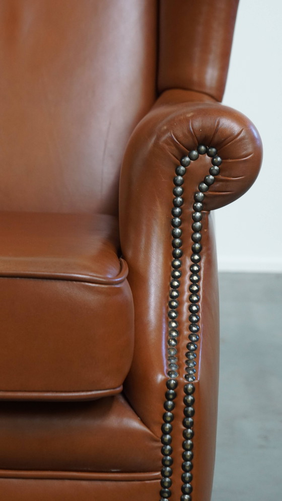 Image 1 of Cognacfarbener Rindslederohrensessel im englischen Stil mit Ziernägeln