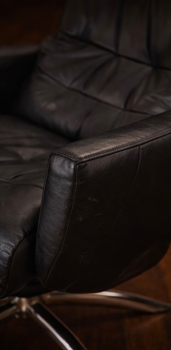 Image 1 of Modernist black leather armchair with a chrome X-frame base in a contemporary style, in good condition with minor signs of aging