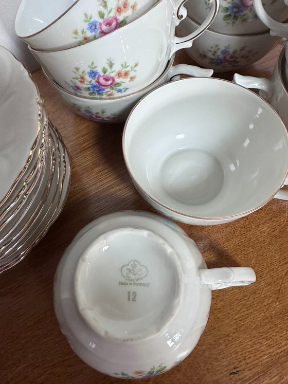 Image 1 of 11 tazze e 9 piattini vintage in porcellana bianca con decorazioni floreali, risalenti al XX secolo e numerati.