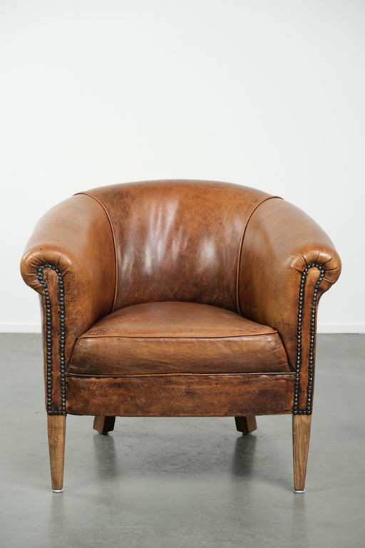 Sillón club vintage de piel de oveja en un tamaño discreto con hermosos colores cálidos.