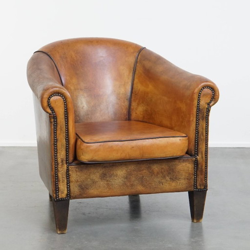 Fauteuil club vintage en cuir de mouton avec rivets décoratifs et passepoils noirs