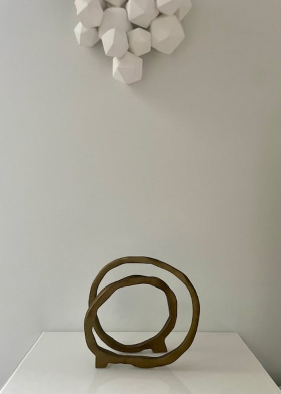 Image 1 of Escultura de diseño con forma de anillo abierto en oro mate.