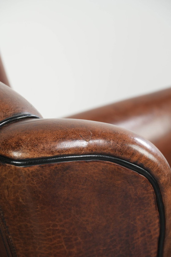 Fauteuil unique en peau de mouton aux couleurs chaudes et profondes, orné d'un passepoil noir. – Leather (photo 13 of 14)