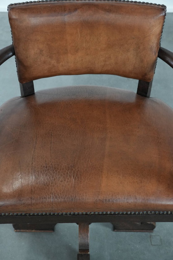 Image 1 of Elegante antieke schapenleren bureaustoel met een zwaar houten frame